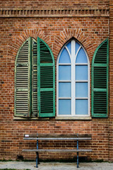 Green shutters and arched window in a historical building near Turn, Italy