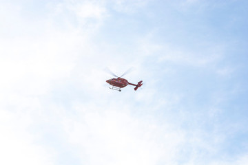Red rescue helicopter making landing approach in the distance