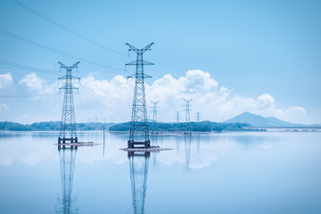 power transmission tower on lake