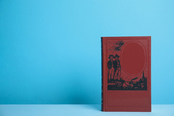 Hardcover book on blue background. Space for design