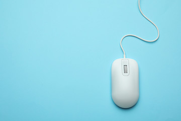 Wired computer mouse on light blue background, top view. Space for text