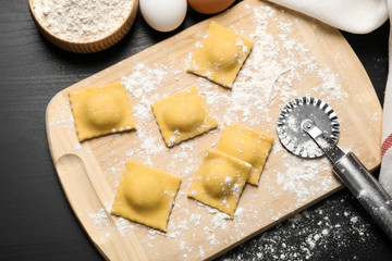 Flat lay composition with raw ravioli on grey table. Italian pasta