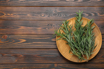 Bunch of fresh rosemary on wooden table, top view. Space for text