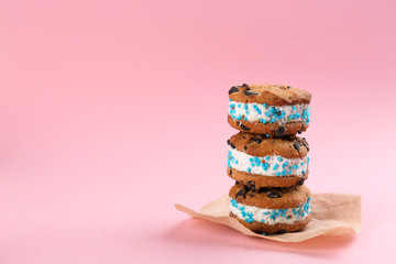 Sweet delicious ice cream cookie sandwiches on pink background. Space for text