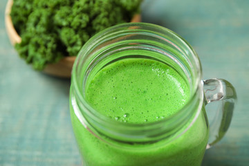 Tasty fresh kale smoothie on light blue table, closeup