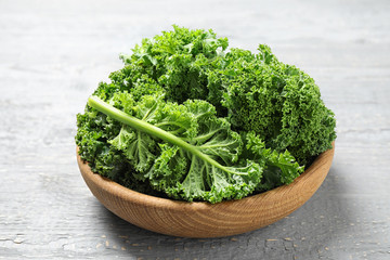 Fresh kale leaves on light grey wooden table