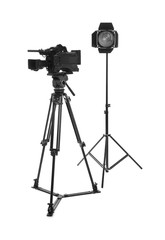 Professional video camera and lighting equipment isolated on white