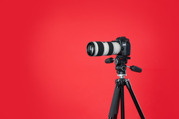 Modern professional video camera on red background