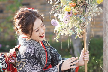 着物姿の若い女性と花