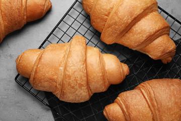 Tasty fresh croissants on light grey table, flat lay