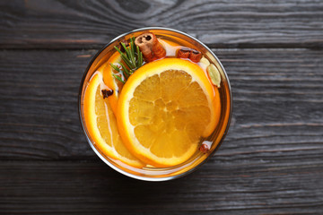 Aromatic mulled wine on black wooden table, top view