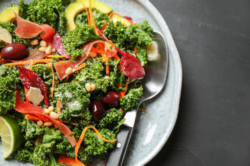 Tasty fresh kale salad on grey table, closeup