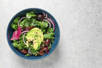 Tasty fresh kale salad on light grey table, top view. Space for text