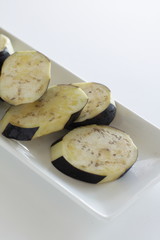olive oil and sliced eggplant on dish with copy space