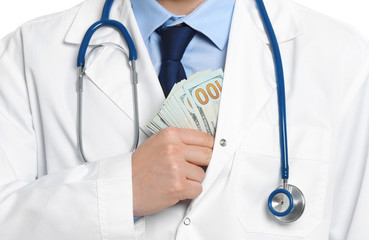 Doctor putting bribe into pocket, closeup. Corruption in medicine