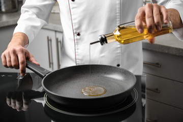 Man pouring cooking oil from bottle into frying pan, closeup