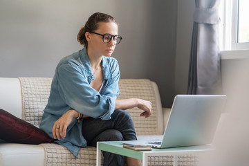 Young pretty european woman with glasses psychologist coach holds an online session on the internet, remote work from home, online consultations