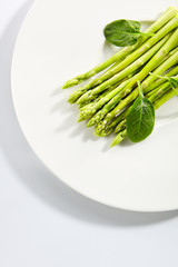 Fresh Young Asparagus Stalks and Green Spinach Leaves Isolated