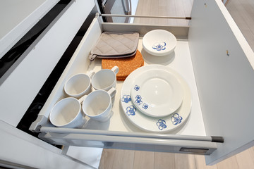 dishes mugs plates in cabinet drawer