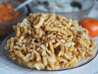 Cake anthill or chuck-chuck with honey filling, on the background of a table with another meal.