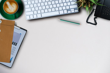 Office supplies are tablet, pen, computer, notebook, mobile phone and green coffee mug placed at an...