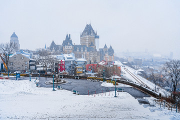 Quebec city skyline cityscape view with snow covered buildings and ground during blizzard in snowfall season