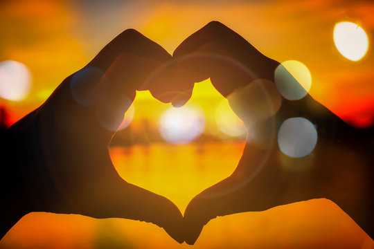 Love silhouette hand shape in the evening sunset time concept valentines day