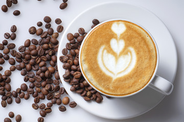 Cup of coffee latte art and coffee beans close up so refreshing and natural