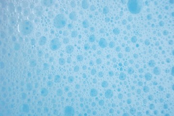 blue soap foam macro background.soap bubbles blue pastel color with a white gradient. Detergent texture. Shower gel. Purity and freshness. 