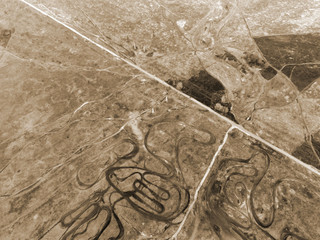 Curved pattern of dirt road, similar to the lines drawing geoglyphs of the Nazca desert.Aerial view...