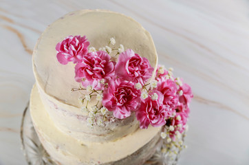 Wedding naked cake decorated with pink flowers closeup