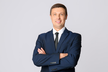 Portrait of handsome businessman on grey background