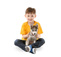 Obraz premium Little boy with cute husky puppy on white background