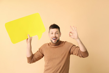 Man with blank speech bubble showing OK on color background