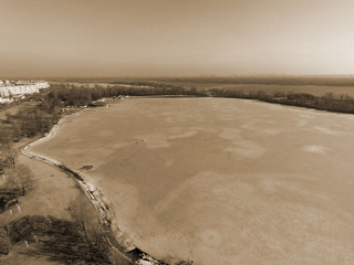 Frozen bay of Dnepr river in residential area of Kiev at winter time (drone image) .Many fishers on ice. Danger hobby. End of winter.  Kiev,Ukraine