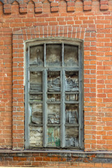Fototapeta na wymiar antique window with broken glass in a brick wall