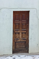 Fototapeta na wymiar antique door brown wooden with square ornaments in a light wall