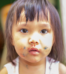 The face image of an Asian girl with a mess from eating