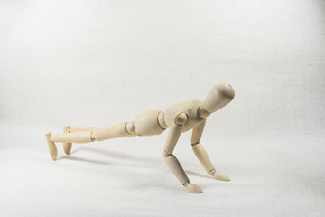 A puppet doing push-ups on a white background.
