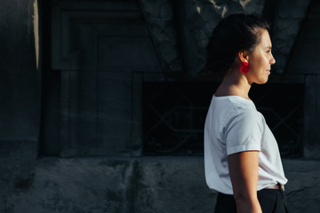 portrait of young pretty woman at city street sunset light