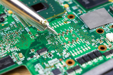 Technicians are using a soldering iron for repairing electronic of the computer circuit board concept technology of computer circuit hardware.