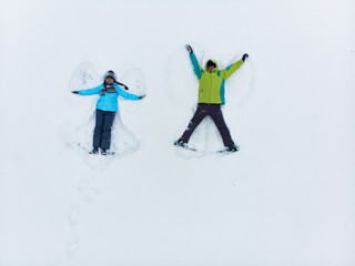 couple having fun making snow angel