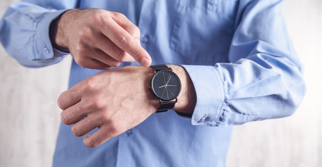 Obraz na płótnie Canvas Caucasian man showing wristwatch in office.