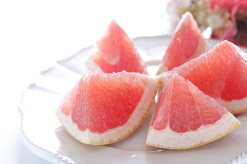 Cut fruit, red ruby grapefruit on dish for healthy dessert