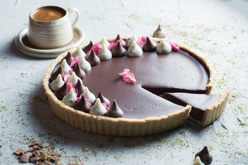 Chocolate tart with a cup of coffee on wooden table with copy space.
