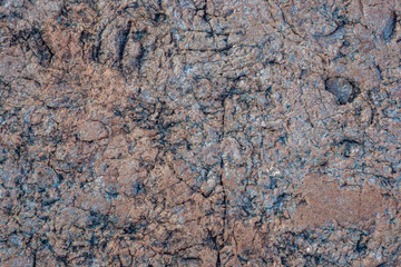 Natural stone background. Gray-brown natural stone. Granite. Natural material. Patterns on the cobbles. Raw stone.