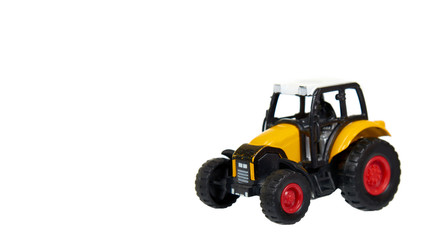 Yellow plastic traktor toy. Farming vehicle, harvest equipment.