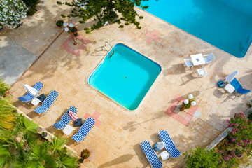 Top view of the pool and sun loungers. Relax and swim in the pool. Hydrotherapeutic procedure. Rest at the resort. Relaxation. Sunbathing by the pool. Balneological resort. Recreation.