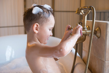   little boy bathes in a bathtub,
