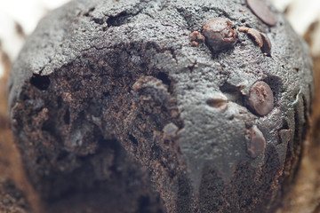Close up on a homemade chocolate muffin  has been bite on a wooden table
